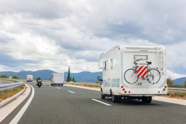 Manzaralı bir grup modern beyaz aile karavan karavanı Avrupa otoyolu Alp dağı bulut yaz günü bulutlu gökyüzü sürüyor. Gezinen yaşam tarzı seyahat topluluk macera yolculuğu.