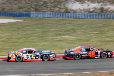 Oschersleben, Germany, September 24, 2023: Scenic view battle fast Nascar Whelen Euro Series at Oschersleben Motorsport Arena race track. European American motors auto sport competition. clipart