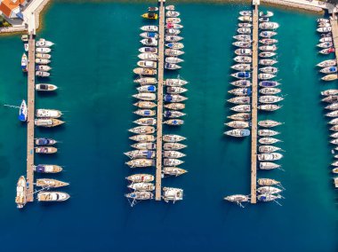 Açık yaz güneşli bir günde, Hırvat körfezi kıyı şeridine demirlemiş pek çok yat manzaralı mavi turkuaz berrak su. Akdeniz marinasının tepesinde. Tekne kiralama servisi.