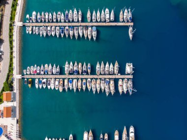 Açık yaz güneşli bir günde, Hırvat körfezi kıyı şeridine demirlemiş pek çok yat manzaralı mavi turkuaz berrak su. Akdeniz marinasının tepesinde. Tekne kiralama servisi.