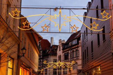 Charming Quedlinburg şehir akşam sokak manzarası Noel ışıkları Herrnhutter yıldızlarıyla aydınlatılmış tarihi yarı keresteli evler cephesinde. Almanya 'da Alacakaranlık Festivali