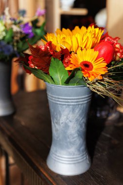 Kırsal köy çiftlik evinin ahşap masasında, Rustik Metal vazosundaki canlı Sonbahar Çiçeği Buketi. Kova içinde parlak çiçekli kompozisyon. Doğa bahçesi çiçek aranjmanı.