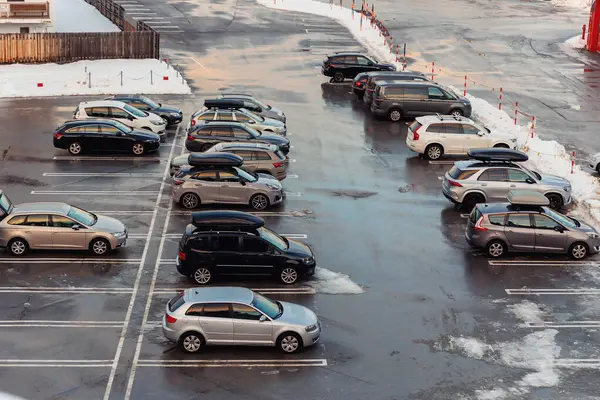 Stock image View from above on car parking with many vehicles and free lots at bright early frosty cold winter morning. Parking lot with snowdrifts near airport terminal or shopping business mall at cold weather.