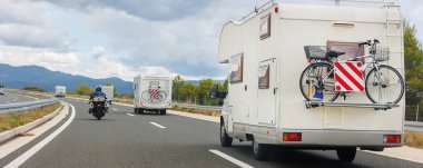 Manzaralı bir grup modern beyaz aile karavan karavanı Avrupa otoyolu Alp dağı bulut yaz günü bulutlu gökyüzü sürüyor. Gezinen yaşam tarzı seyahat topluluk macera yolculuğu.