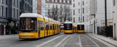 Günbatımında Berlin Mitte merkez bölgesinde park edilmiş birçok modern sarı tramvay manzaralı. Kentsel Avrupa taşımacılığı Almanya 'nın şehir manzarası arka planını değiştirdi.