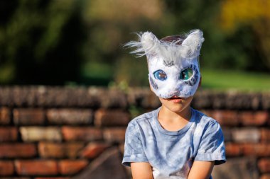 Cute young little kid boy wear cat furry mask enjoy have fun playing outdoors in forest street park. Children therian wild animal character trendy fan culture. Teenager social expression hobby. clipart