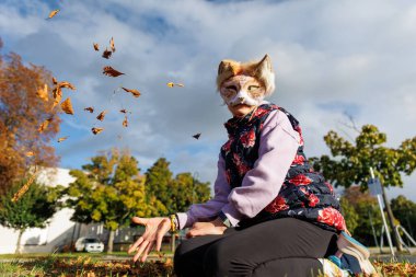 Şirin küçük kız çocuk kedi kürklü maskesi takıyor. Forest Street Park 'ta dışarıda oynarken iyi eğlenceler. Çocuklar, vahşi hayvan karakteri moda hayran kültürü. Gençlerin sosyal ifade hobisi.