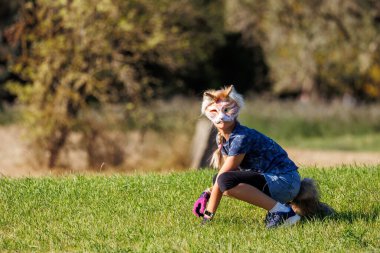 Cute young little kid girl boy wear cat furry mask enjoy have fun playing outdoors in forest street park. Children therian wild animal character trendy fan culture. Teenager social expression hobby. clipart