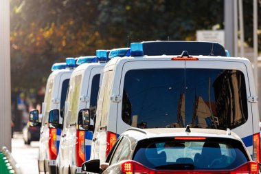 Güneşli bir günde şehir merkezindeki trafik ışıklarında bir çok Alman polis minibüsü görülüyor. Avrupa Sivil Acil Durum Kanunu Trafik Hizmeti Aracı. Etkinlik güvenlik servisi.