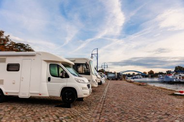 Manzaralı bir çok karavan Elbe nehri kıyısındaki kamp yerine park etmiş. Yolcu gezisi yolcu gemisi sabah güneşinin doğduğu gökyüzüne yanaştı. Karavan istasyonunun varış noktası. Karavan yaşam biçimi.