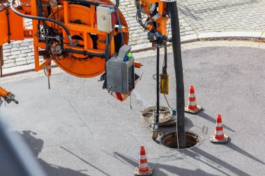 Boru hortumu kanalizasyon kamyonu motoru şehir kanalizasyon kanalını boşaltıyor. Septik temizlik, elektrik süpürgesi bakım teknolojisi ekipman endüstrisi. Aspirasyon aracı temizleme makinesi drenaj pompalıyor.