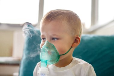 Sevimli küçük çocuk tıbbi nebulizör maskesi takıyor buhar solunum terapisi ciğerleri ve RSV alerji tedavisi soluyor. Portre çocuğu mevsimlik solunum bronşit öksürük ilacı tedavisi görüyor..