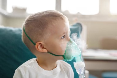 Sevimli küçük çocuk tıbbi nebulizör maskesi takıyor buhar solunum terapisi ciğerleri ve RSV alerji tedavisi soluyor. Portre çocuğu mevsimlik solunum bronşit öksürük ilacı tedavisi görüyor..