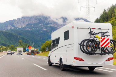 Manzaralı büyük beyaz aile karavan aracı yaz günü Avrupa otoyol alp dağ bulutu sürüyordu. Karavanda seyahat ve macera turizmi seyahat konsepti. uk