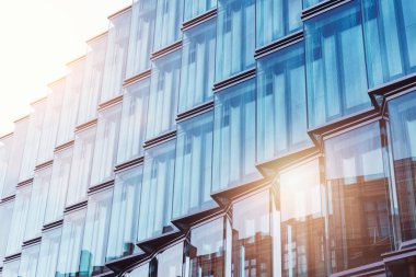 Berlin Mitte kentsel caddesinde günbatımında günbatımında güneş ışığı parlayan modern cam metal yüksek bina cephesinin görüntüsü. İşletme Finansal Ofisi Geleceksel Mimari.