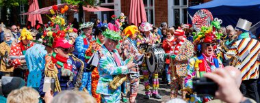 Potsdam, Almanya - 21 Nisan 2024: Hollanda Lale Festivali Hollanda Lale Festivali Hollanda 'nın Potsdam Mahallesi' nde canlı sokak müzisyenleri grubu. Komik insanlar bahar karnaval partisini kutluyor..