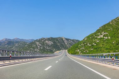 Açık yol, parlak gökyüzünün altındaki yeşil dağların arasına çıkar. Hırvatistan 'ın bu güneşli otoyolu, bereketli bir Akdeniz manzarasında özgürlük ve manzaralı bir yolculuk yakalayarak sonsuz keşifleri davet ediyor.