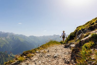 Manzaralı arka manzara genç yetişkin kadın yürüyüş manzarası, güneşli ve sıcak günbatımının keyfini çıkarıyor. Kadın mutlu kişi Grossglockner Zirvesi 'ni keşfediyor..