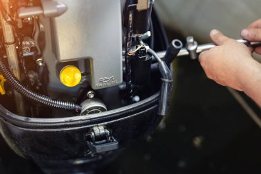 tekne garajında şişme motorlu tekne motoru tamir mekanik. Gemi motoru mevsimlik servis ve bakım. Açık kapaklı gemi motoru.