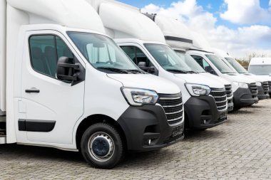 Yeni modern elektrikli hidrojen ya da dizel beyaz minibüsler açık havada park halinde. Kargo şilebi endüstriyel kurye ulaşım lojistik servisi. Ticari araç bakım sigortası.