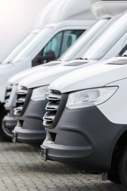 Yeni modern elektrikli hidrojen ya da dizel beyaz minibüsler açık havada park halinde. Kargo şilebi endüstriyel kurye ulaşım lojistik servisi. Ticari araç bakım sigortası.