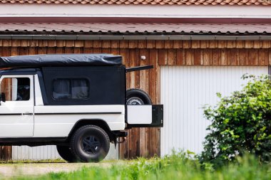 Kırsal Almanya 'nın kırsal kesimine park etmiş off-road beyaz SUV arabası. Tüm arazi arazi arazi arazi karavan dinlenme aracı çatı çadır raf macera keşfetmek için güneşli yaz günü yaşam tarzı.