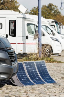 Birçok modern park etmiş karavan pille taşınabilir güneş panellerini temiz eko enerjiyle şarj ederek güneşli yaz günlerinde şebeke dışı seyahat özgürlüğüne olanak sağlıyor. Yaratıcı sürdürülebilirlik teknolojisi.