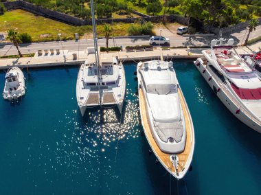 Açık yaz güneşli bir günde, Hırvat körfezi kıyı şeridine demirlemiş pek çok yat manzaralı mavi turkuaz berrak su. Akdeniz marinasının tepesinde. Tekne kiralama servisi.
