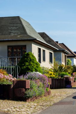 Tek aile modern evlerin olduğu şehir caddesinde çiçekler açan Almanya yeşil çitlere uzanır. Alman banliyösü küçük kasaba yerleşim alanı sıra çevresi sürdürülebilir hayat inşa eden banliyö banliyösü.