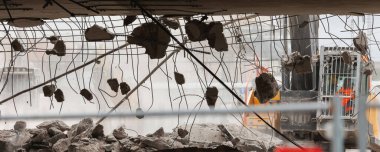 Magdeburg Damaschkeplatz 'daki yıkılan köprünün yakın plan görüntüsü beton parçaları düşen çelik demiri ortaya çıkardı. Harabe yığınları ve yıkım makineleri yıkım sürecini vurguluyor.