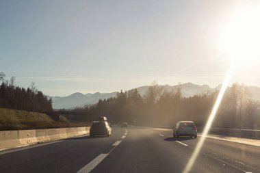 Avrupa 'nın dağlık kesimindeki soğuk kış gününde dağlık otobanı kullanan manzaralı arabalar. Kış tatili kayak sezonu. Tatil ulaşım yolu tepe noktası.
