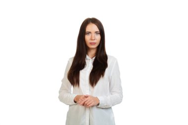 Sakin, genç, güzel bir kız beyaz bir arka planda beyaz gömlekli..