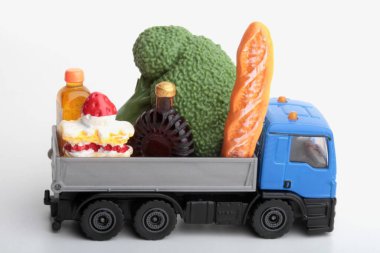 Oyuncak kamyonu teslimat için yiyecek dükkanı taşıyor.