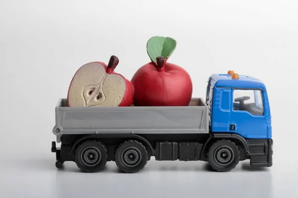 Red apples  and a toy truck on a white background
