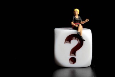 Soru işaretinin üzerinde oturan kadın minyatür figür