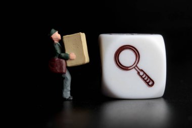 Paketi ve büyüteci olan bir teslimatçının minyatür biblosu, nakliye takibinin sembolü.