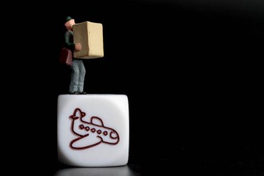 Bir teslimat kuryesinin minyatür biblosu bir uçağın simgesi olan bir paket tutuyor. 