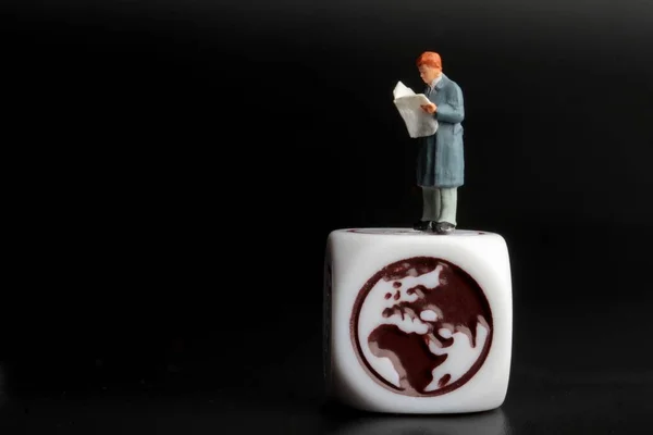 Miniaturowa Figurka Człowieka Czytającego Wiadomości Międzynarodowe Gazecie — Zdjęcie stockowe