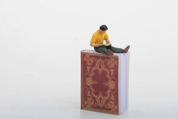 Miniaturowa Figurka Studenta Czytającego Gigantyczną Książkę — Zdjęcie stockowe