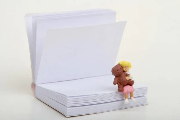 Miniaturowa Figurka Dziewczynki Pluszowym Miśkiem Siedzącej Gigantycznej Książce — Zdjęcie stockowe