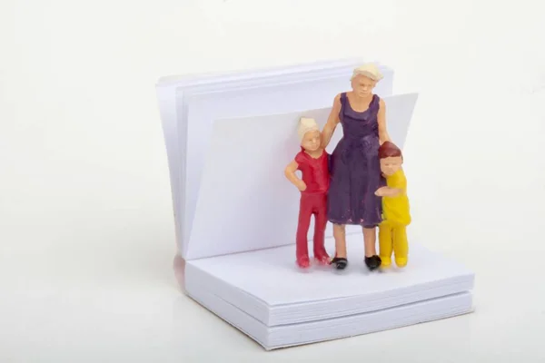 Estatuetas Miniatura Uma Mãe Com Seus Filhos Livro Aberto — Fotografia de Stock