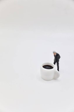 Masada kahve fincanı ve bir iş adamının minyatür biblosu.