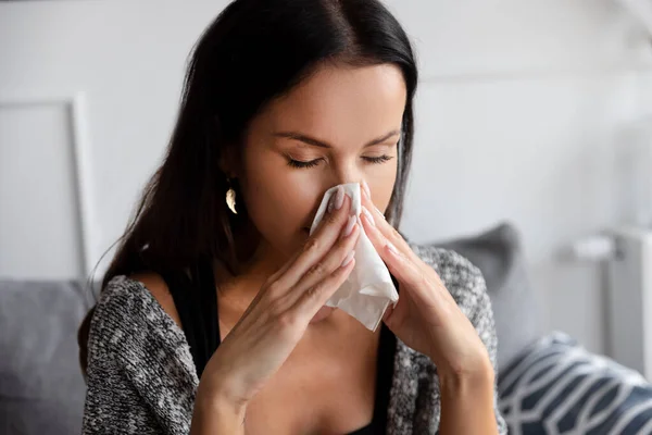 Sick woman blowing her nose. Woman caught cold.