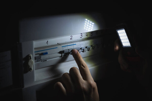 Investigate a home fuse box during a power outage. Blackout concept