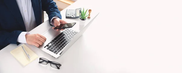 オフィスで働くノートパソコンやスマートフォンを持つビジネスマン — ストック写真
