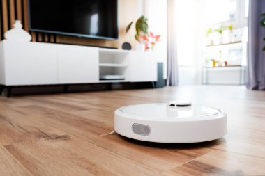Beyaz robot aşı temizleyicisi oturma odasında yerde, akıllı ev aleti