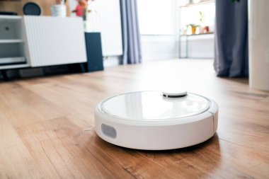 Beyaz robot aşı temizleyicisi oturma odasında yerde, akıllı ev aleti