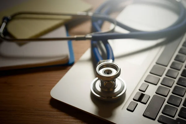 手提电脑键盘上的听诊器 远程保健 远程医疗概念 — 图库照片
