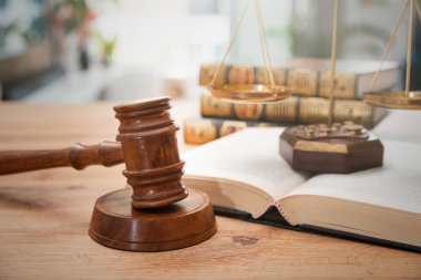 Arka planda kitaplar olan tahta tokmak. Hukuk ve adalet kavramı