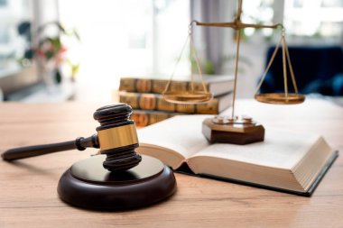 Arka planda kitaplar olan tahta tokmak. Hukuk ve adalet kavramı